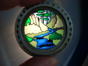 Sunburst Nature Walk Geocoin when held up to a light